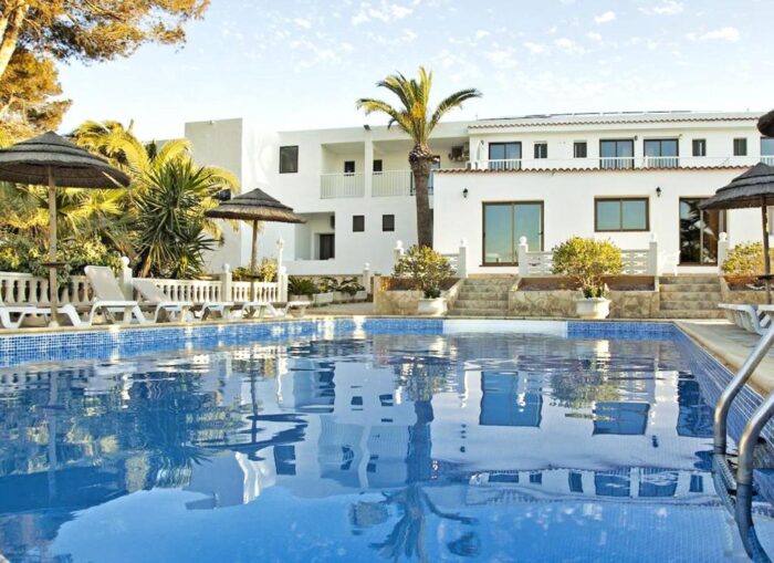 La piscina y la fachada del hotel.