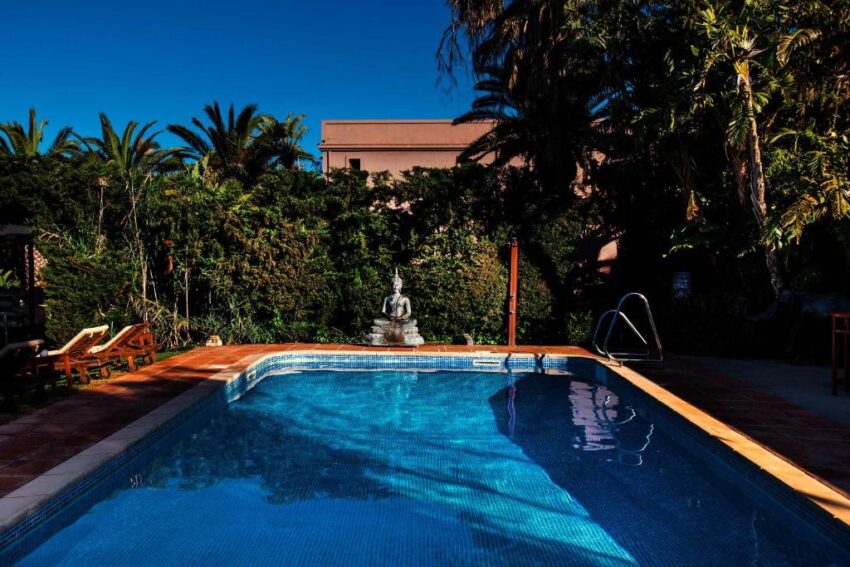 La piscina, rodeada de jardines.