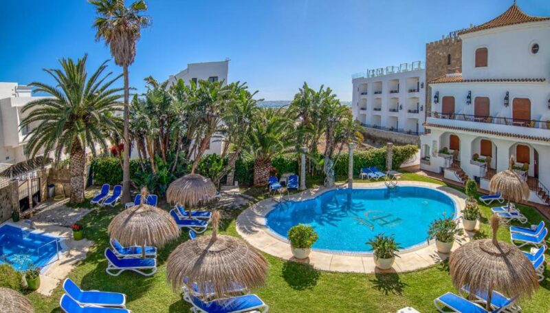 El edificio del hotel, con la piscina y jardines.